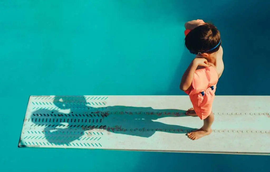 boy looking at shadow on diving board 1365208730