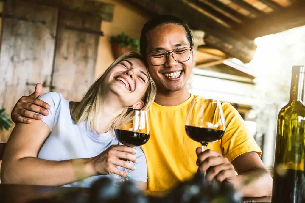 couple laughing drinking wine 1988776247