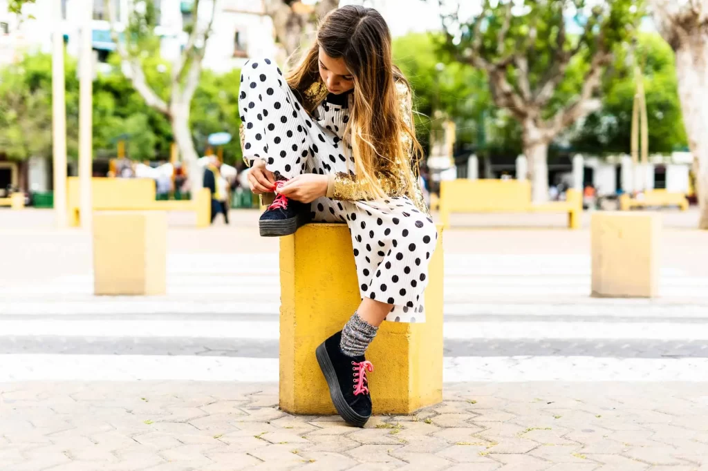 girl in polka dots tying shoe offset 822950