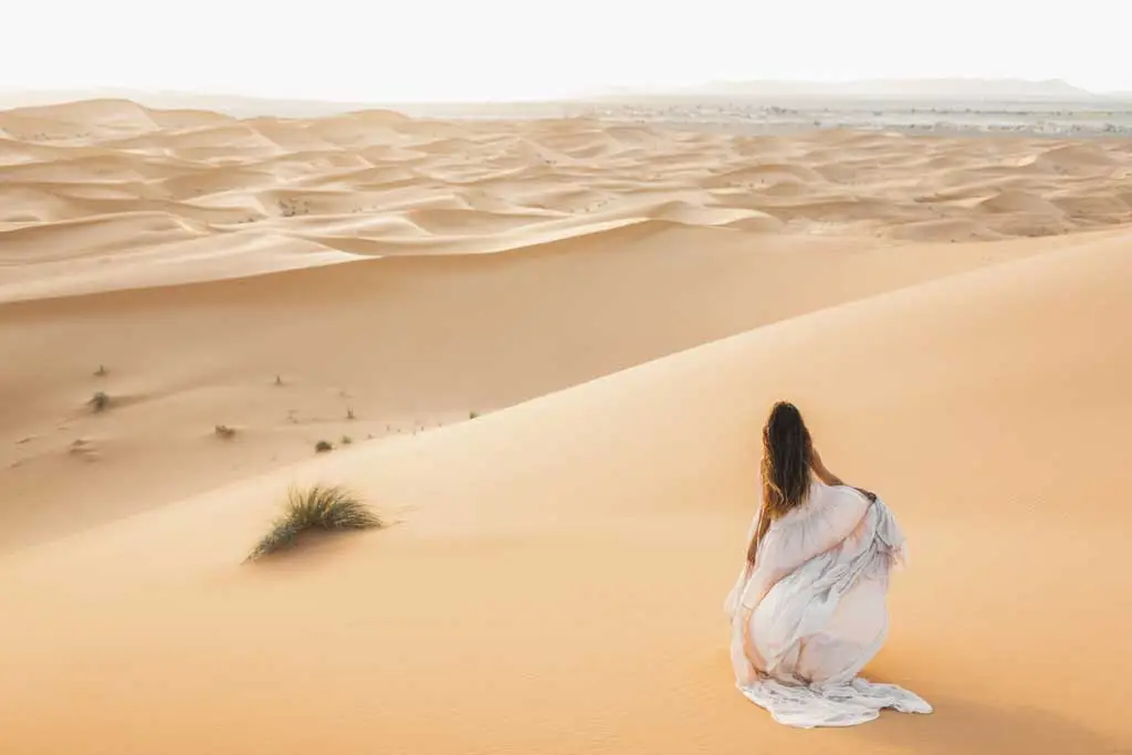 woman in flowing dress on sand dunes