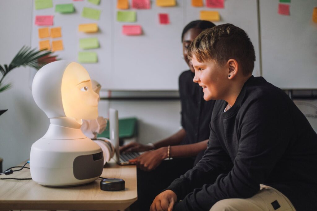 Smiling,Boy,Communicating,With,Illuminated,Ai,Robot,In,Innovation,Lab