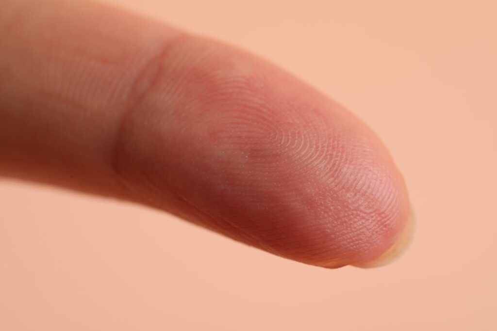 Closeup,View,Of,Woman's,Finger,On,Beige,Background